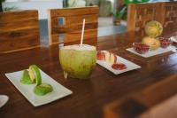 Ein Holztisch mit einem Getränk und Obst auf Tellern in der Unterkunft Ayurprana Marari in Mararikulam