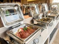 een buffet met drie dienbladen eten op een aanrecht bij Jinmanfu International Hotel in Huadu
