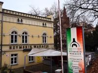 Ein Schild vor einem Gebäude mit einer Flasche Wein in der Unterkunft Rzymskie wakacje in Oppeln