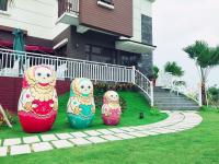 three colorful vases sitting in the grass in front of a house at Sophia B&amp;B in Dongshan