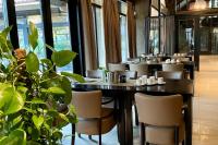 ein Esszimmer mit Tischen, Stühlen und einer Pflanze in der Unterkunft Luxe Chalet Leeuwenhart - recreation only in Hoenderloo