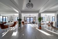 a dining room with white tables and chairs and windows at Zodia Craiului in Peştera