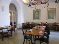 Un comedor con mesas y sillas de madera. en Fort Bazaar, en Galle