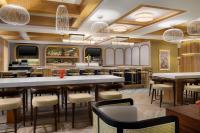 een restaurant met een bar met tafels en stoelen bij EVEN Hotel Detroit North - Troy by IHG in Troy