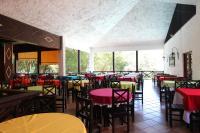 a restaurant with tables and chairs with red and yellow tables at Hotel Mato Grosso Águas Quentes in Sucuri