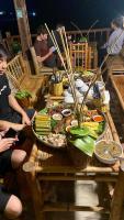 枚州县Meadow Mai Chau Homestay的一群人坐在餐桌旁,吃着各种食物