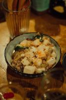 a bowl of food on a table with a glass at Hostel&Bar CAMOSIBA in Yokote