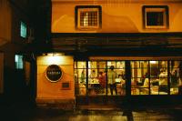 a group of people standing outside a restaurant at night at Hostel&Bar CAMOSIBA in Yokote