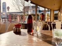 una bottiglia di soda appoggiata su un tavolo di legno di Abelha Hôtel Le France a Brive-la-Gaillarde