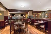 Un restaurante con mesas y sillas y un bar. en The George Washington - A Wyndham Grand Hotel, en Winchester