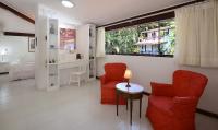 a living room with two red chairs and a bed at Angra Boutique Hotel in Angra dos Reis