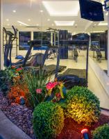 a gym with a fitness room with a treadmill and plants at Angra Boutique Hotel in Angra dos Reis