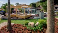 a resort with a bed in the middle of a park at Angra Boutique Hotel in Angra dos Reis
