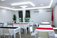 a dining room with white tables and white chairs at Onzo Yamy in Luanda