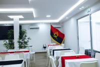 a room with white tables and a flag at Onzo Yamy in Luanda