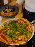 a person holding a pizza on a plate at Pen y Bryn in Conwy