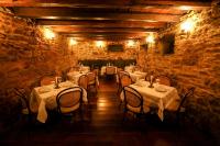 ein Esszimmer mit Tischen und Stühlen in einem Steingebäude in der Unterkunft Hotel Luxor in Ouro Preto