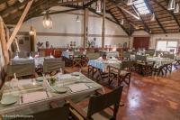 een feestzaal met tafels en stoelen en een man op de achtergrond bij The Sissing Santuary 