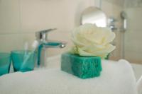 a white rose sitting in a green holder on a sink at Hotel Claro Garni in Eitting