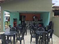 un groupe de tables et de chaises dans une pièce dans l'établissement Pousada Netuno, à Saquarema