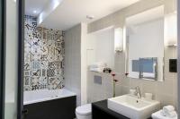 a bathroom with a sink and a tub and a toilet at Hôtel Square Louvois in Paris