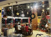 Leute sitzen an Tischen in einem Restaurant mit Weihnachtsbaum in der Unterkunft Essence of Nature, Ranikhet in Rānīkhet