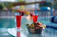 a bowl of fruit on a table with two drinks at Sunrise Dreamworld Resort in Chonp
