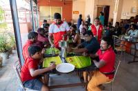 un groupe de personnes assises à une table dans un restaurant dans l'établissement Aryas Residency- Near Isha Foundation Coimbatore & Karunya University, à Alāndurai