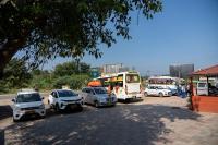 un groupe de voitures garées sur un parking avec des bus dans l'établissement Aryas Residency- Near Isha Foundation Coimbatore & Karunya University, à Alāndurai