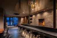 a bar with chairs and a brick wall at KOS Restaurant & Hotel in Fujikawaguchiko