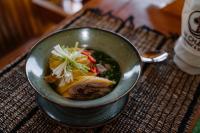 een kom soep met vlees en groenten op een tafel bij An Station - Dorm & Onsen packaged in Ha Giang