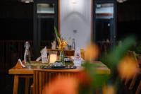 een houten tafel met een kaars en een fles erop bij An Station - Dorm & Onsen packaged in Ha Giang