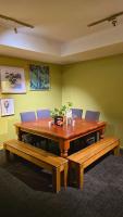 a wooden table and benches in a room at Carramar Motor Inn in Palmerston North