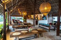 ein Restaurant mit Tischen und Stühlen und eine Bar in der Unterkunft Natural Park Villa Resort in Pingwe