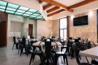 a room with tables and chairs and a flat screen tv at Hotel Grand Lion in Torreón