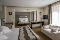 ein Schlafzimmer mit einem Bett, einem Sofa und einem Schreibtisch in der Unterkunft Hôtel Le Bristol Strasbourg Gare in Straßburg