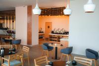 een restaurant met tafels en stoelen en een toonbank bij Crowne Plaza Merida by IHG in Mérida