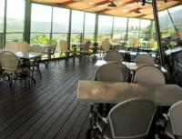 een leeg restaurant met tafels, stoelen en ramen bij Shoresh Green Hills in Shoresh