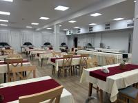 una sala da pranzo con tavoli bianchi e sedie in legno di O W Dab a Ustroń