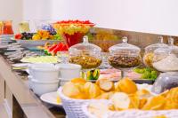 um buffet com pratos de comida e taças de fruta em Easy Hotel Cachoeiro de Itapemirim by Atlantica em Cachoeiro de Itapemirim