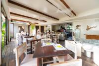 卢纳将军城L'Osteria Luxe Beachfront B&B的一间有木桌椅和厨房的餐厅