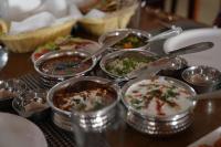 a table topped with different types of food in metal containers at Sunrise Dreamworld Resort in Chonp