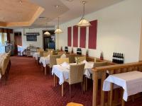 ein Esszimmer mit weißen Tischen und Stühlen in der Unterkunft Hotel Fortuna Reutlingen-Tübingen in Reutlingen