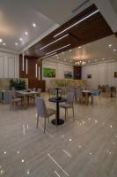 een eetkamer met tafels, stoelen en een tafelblad bij هورايزون بلص in Najran