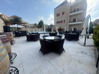 a patio with tables and chairs and a building at Terminal K Bhamdoun Hotel in Aley