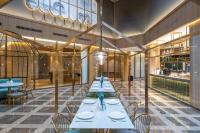 een groep tafels en stoelen in een restaurant bij Orange Crystal Hotel Qingdao Jimo Ancient Town in Jimo