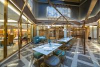 een restaurant met tafels en stoelen in een gebouw bij Orange Crystal Hotel Qingdao Jimo Ancient Town in Jimo