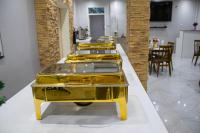 Eine Reihe goldener Tabletts stand auf einem Tisch in der Unterkunft LENNON QUALITY Hotel in Umtali