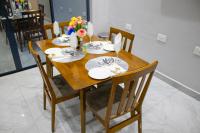 einen Holztisch mit Stühlen, Teller und Blumen darauf in der Unterkunft LENNON QUALITY Hotel in Umtali