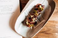 een bord met eten op een lepel naast een boek bij mein werder - hotel am markt in Werder